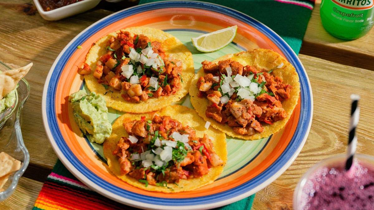 a plate of three pork tacos
