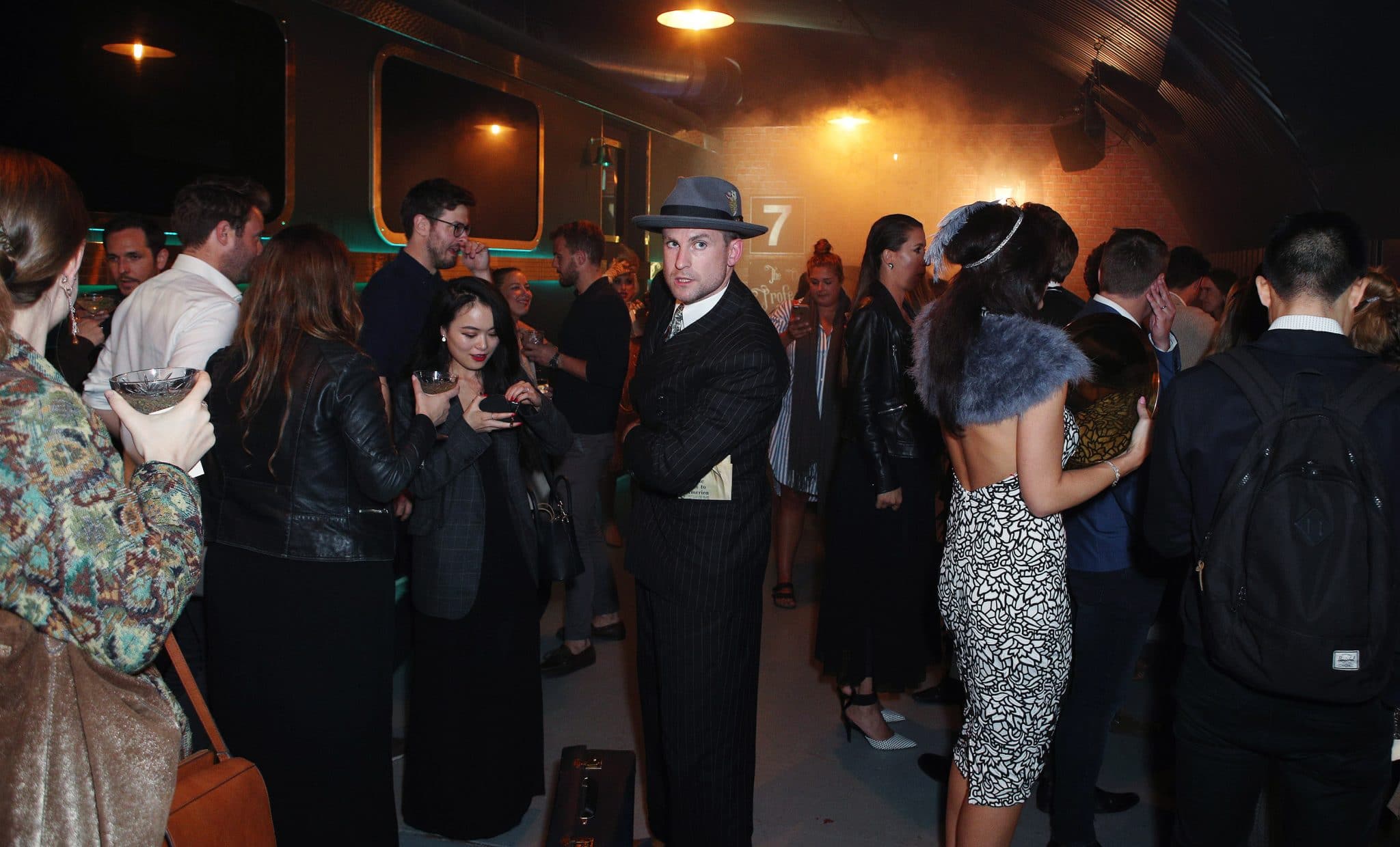  A group of people dressed in 1930s costumes for the murder express immersive dining experience.