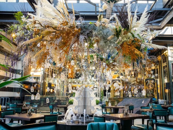 A wide view of Solas, the opulent, floral-inspired dining terrace at The Savoy Hotel.