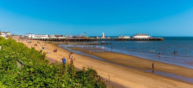 The pier with fairground rides and golden sands at Clacton On Sea