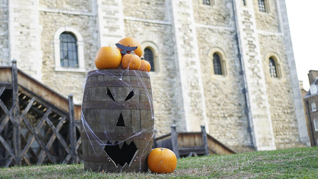 pumpkins placed on a barrel in front of tower of london
