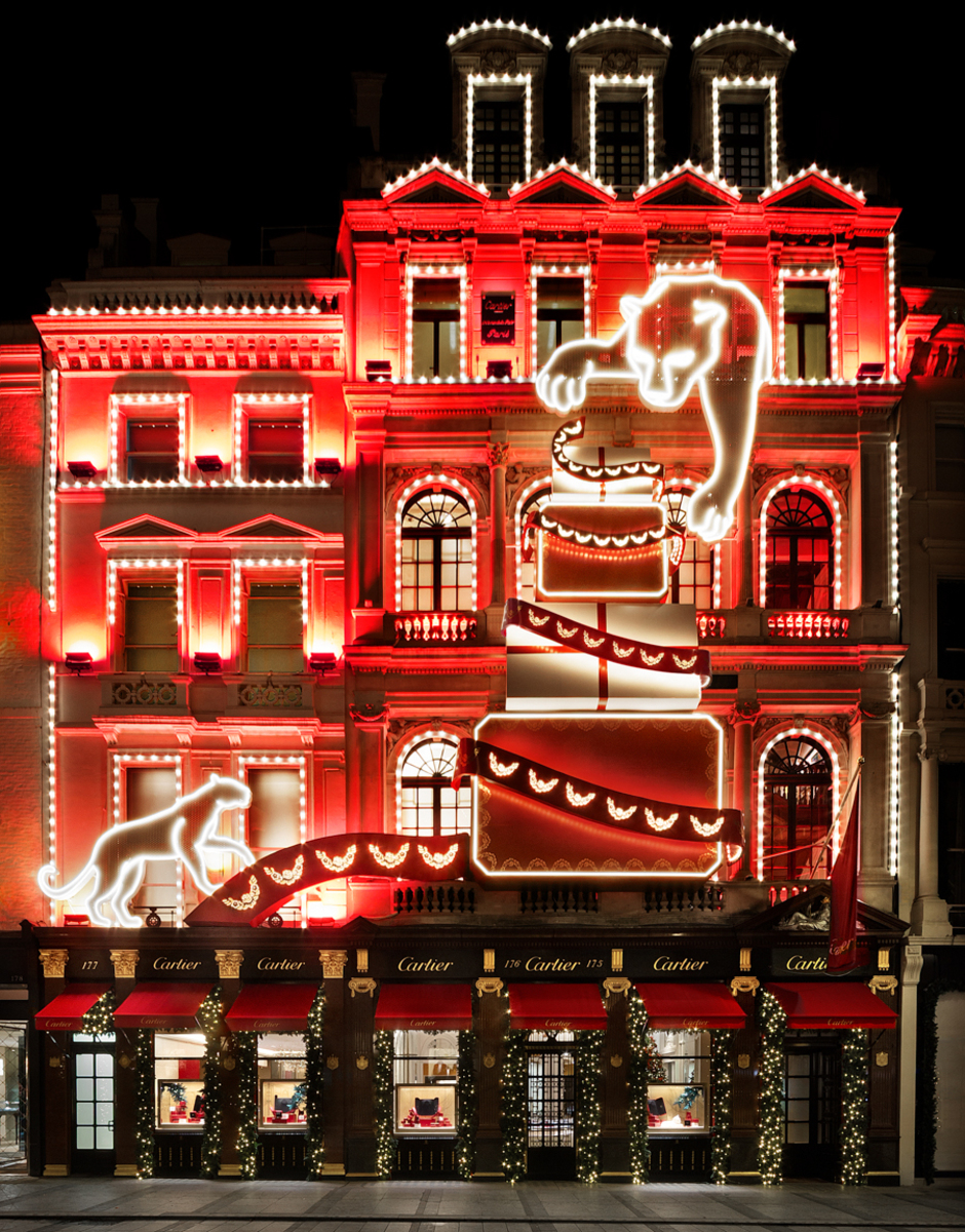 the exterior of the cartier store on bond street, decorated with a red glowing christmas lights display showing a pile of presents and sneaky panthers trying to steal the presents
