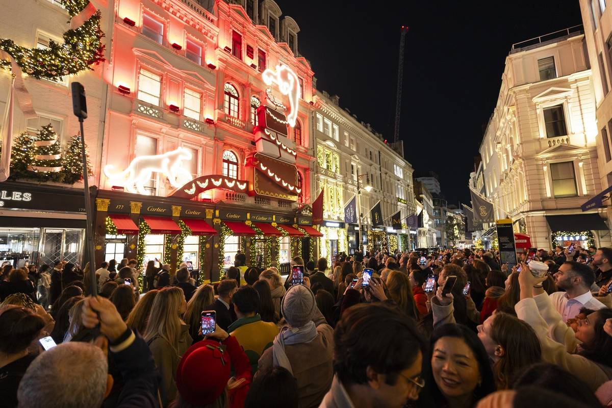 people filling bond street, taking photos of the storefront christmas lights displays lining the streets