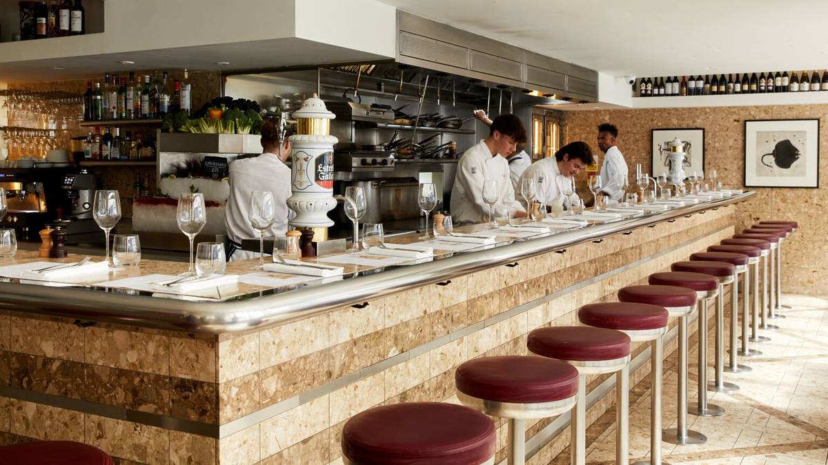 cooks hard at work in the kitchen, behind the counter/bar seating at barrafina