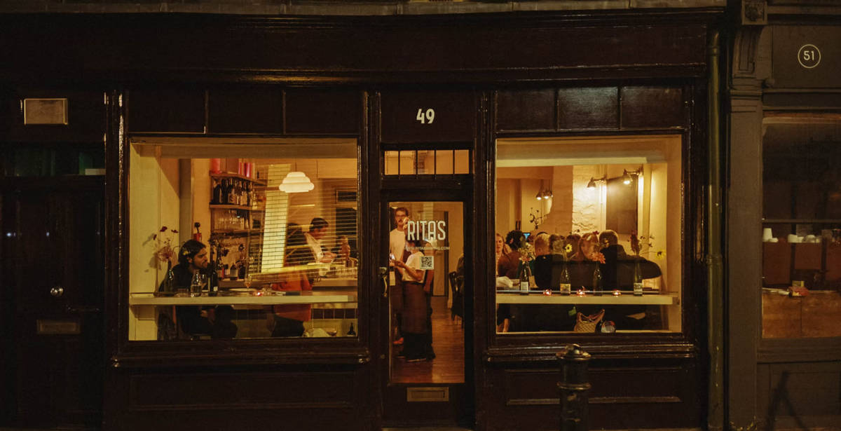 people seen dining at rita's through the window-ed facade of the restaurant