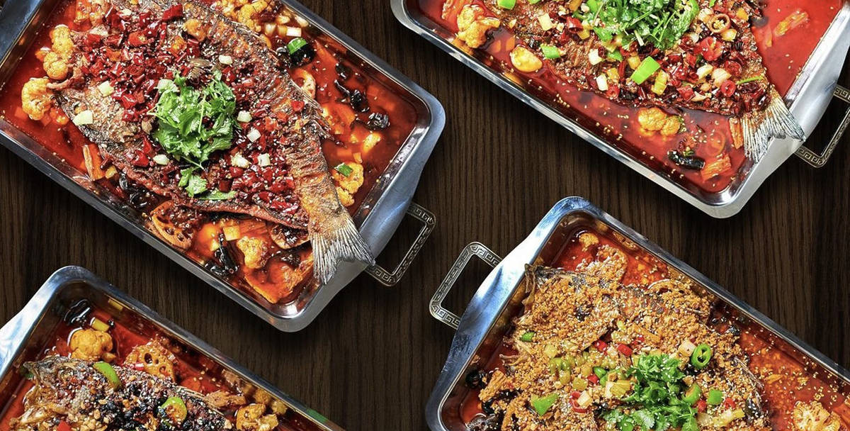 four platters of sichuan style roasted fish swimming in spicy sauce