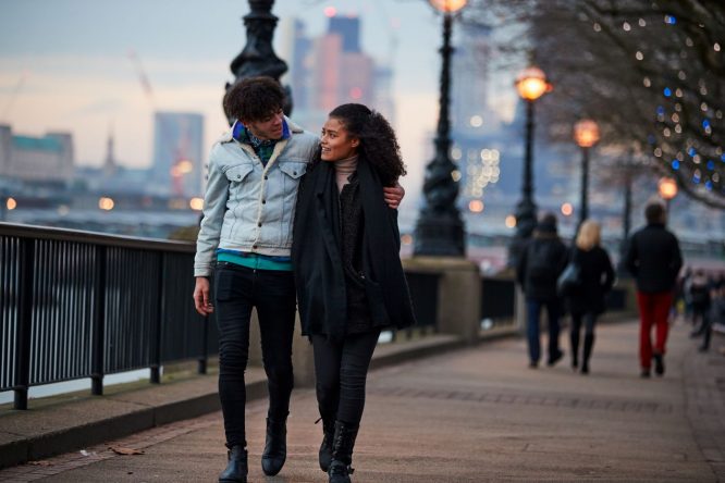 A couple walking down the Southbank in London on a date