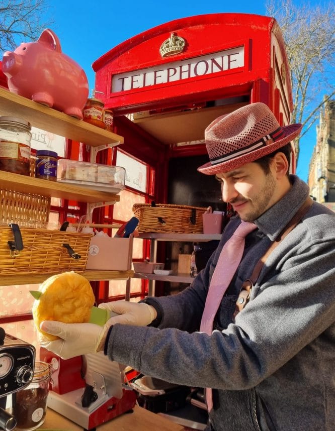 Pinkadella owner Gabriele prepares a focaccia with mortadella inside a red telephone box