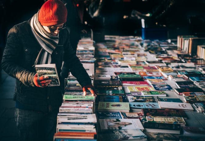 A person looking through books at a car boot sale in London