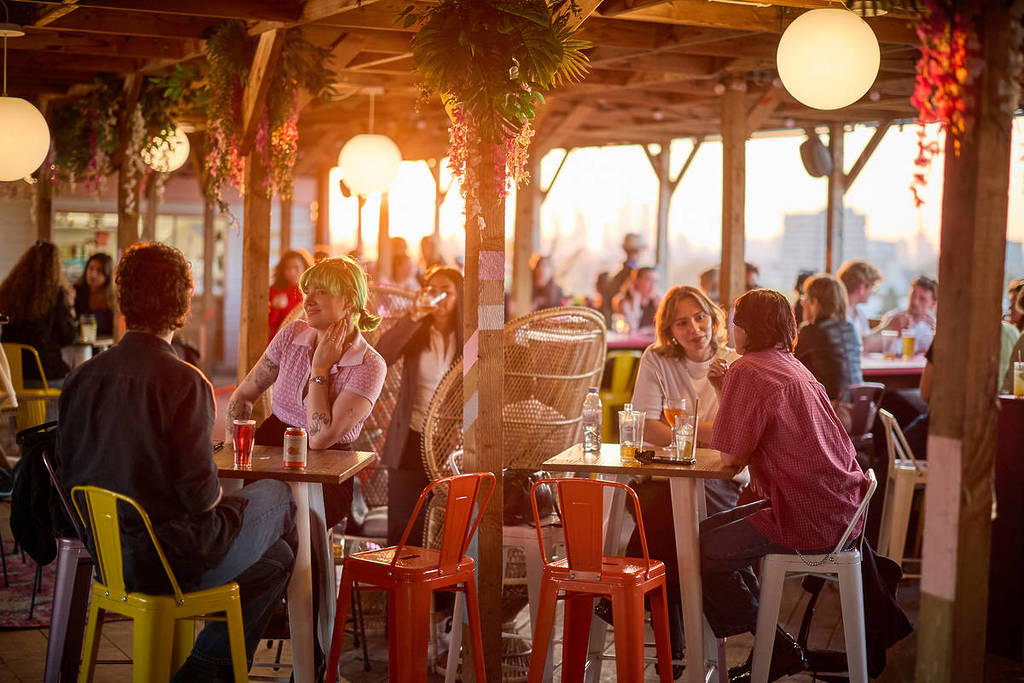 people drink and dine on at the Bussey Building rooftop bar in Peckham