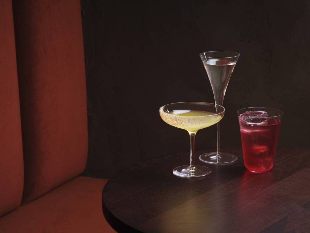 a minimalist image of 3 cocktails in different glasses, one with a spiced rim