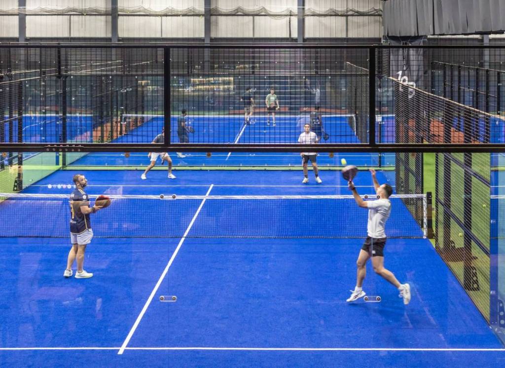 people play padel on a blue court