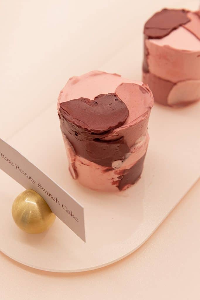 A close-up photo of a pink and red swatch cafe, at the Rare Beauty Cafe in London.