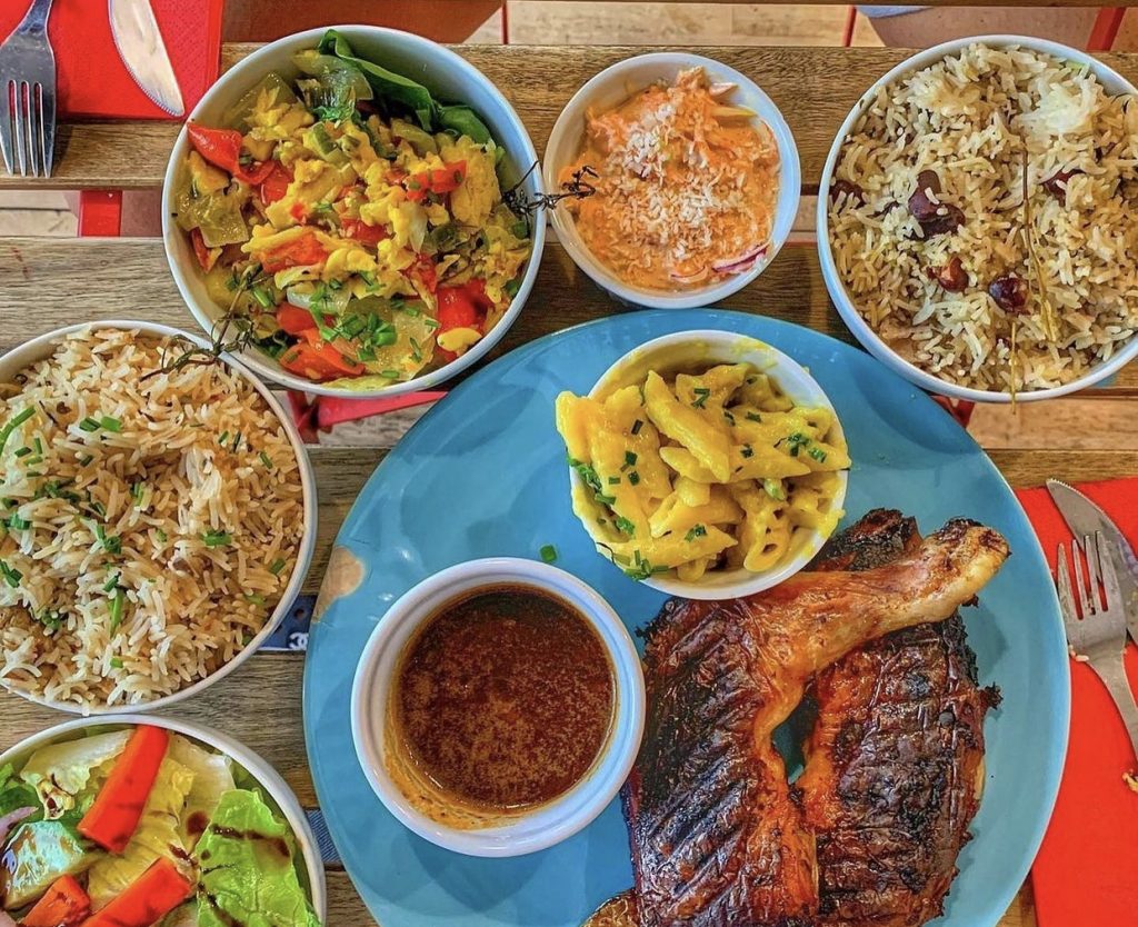 a spread of chicken and Caribbean sides at Sugarcane London