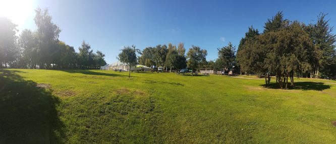 The wide, grassy expanse of The Orchard Campsite in Suffolk, England