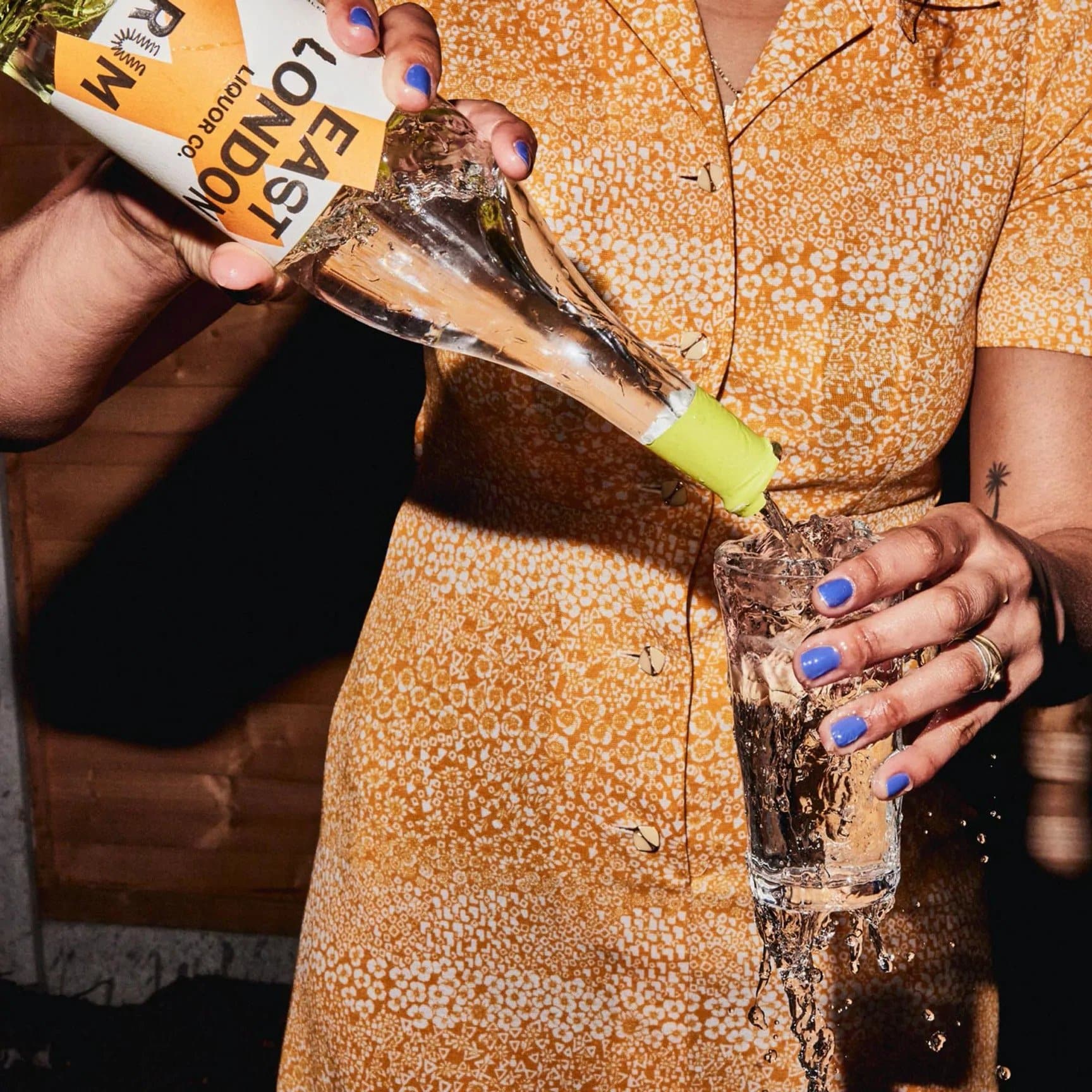 Someone pouring East London rum into an already overflowing glass