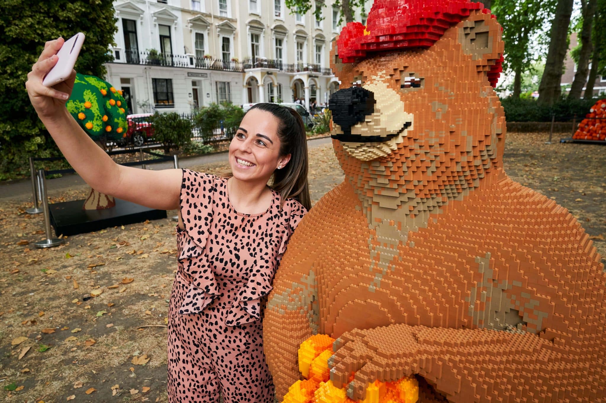 A brick model of Paddington's friend taking a selfie with a visitor to the attraction