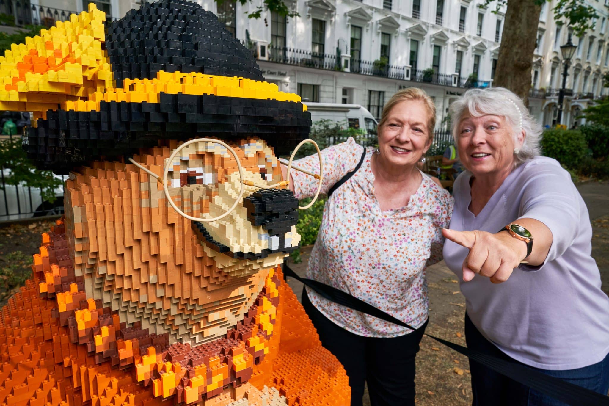 a brick model of one of Paddington's friends, with some visitors to the exhibition