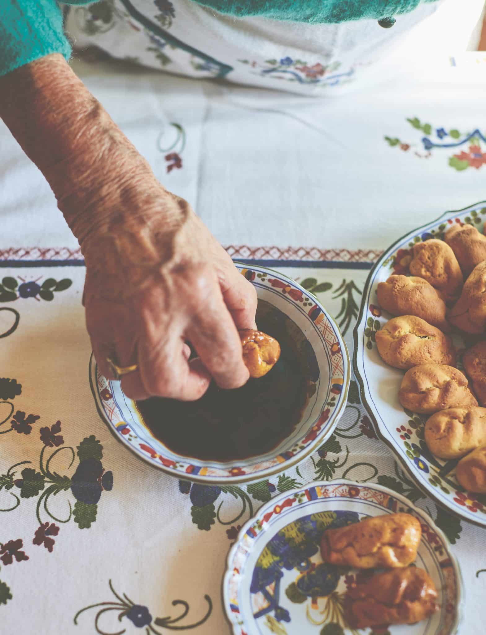 Some ingredients on a table, with a hand performing an act of cooking