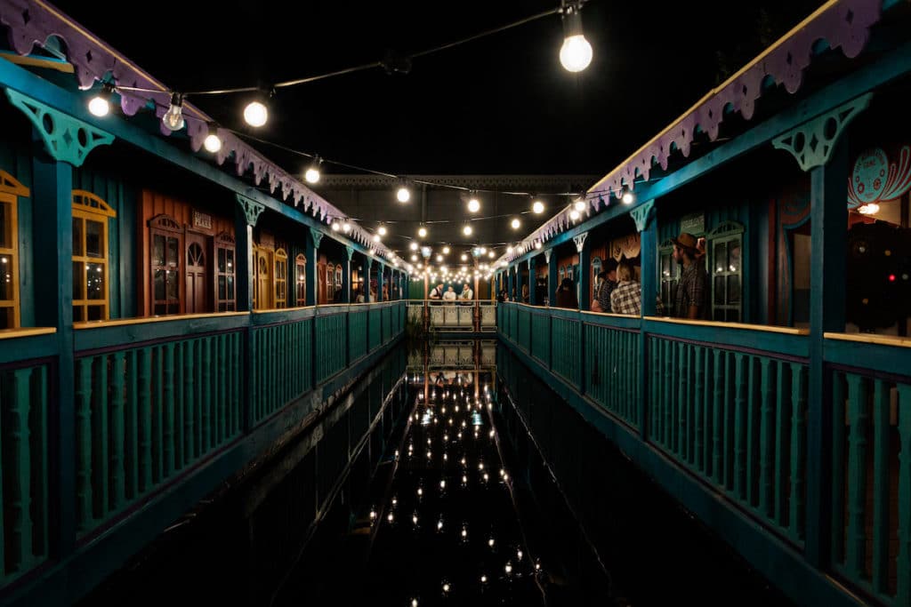 western-style buildings and a waterway strung with lanterns at night