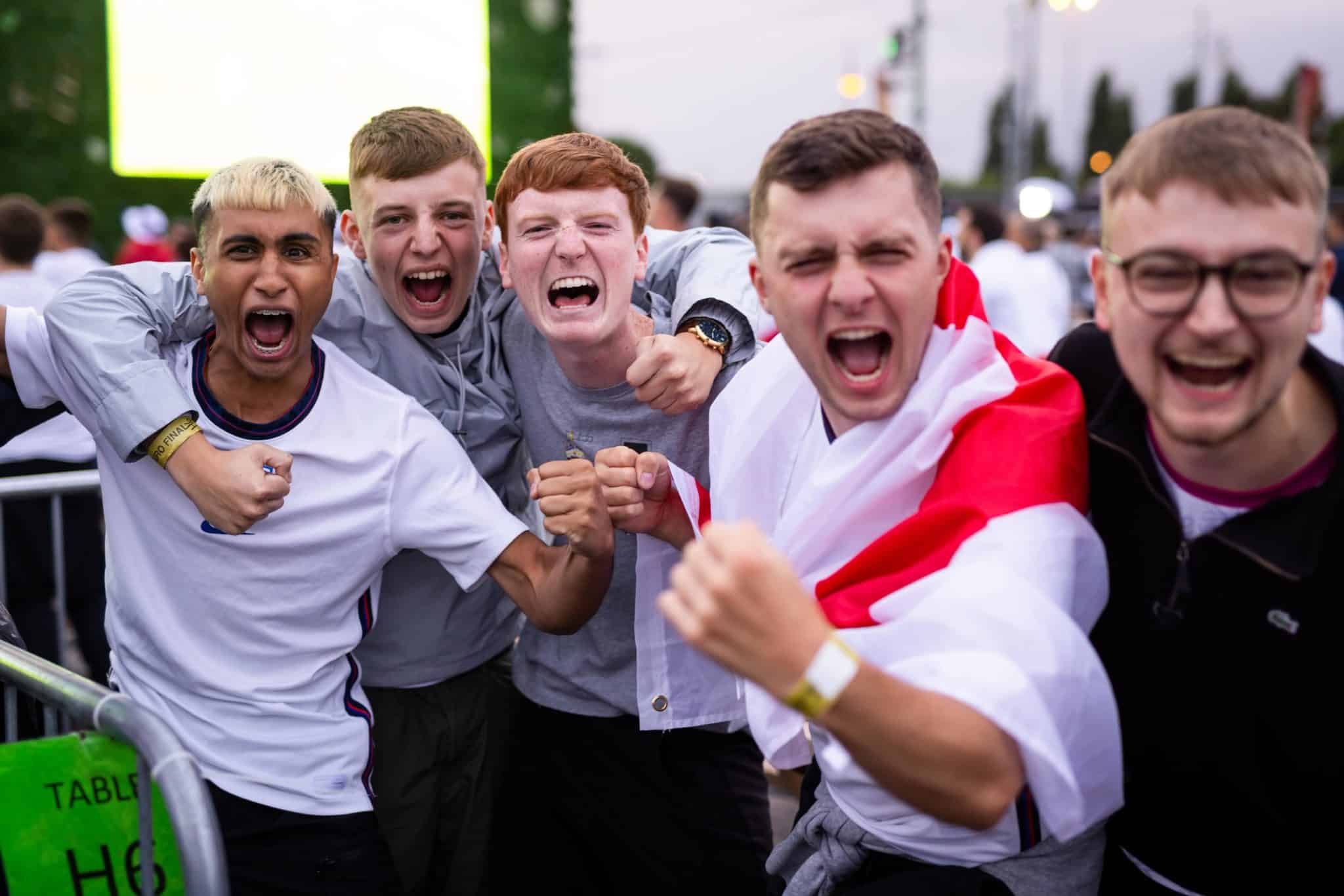 a group of footie fans cheering to the camera