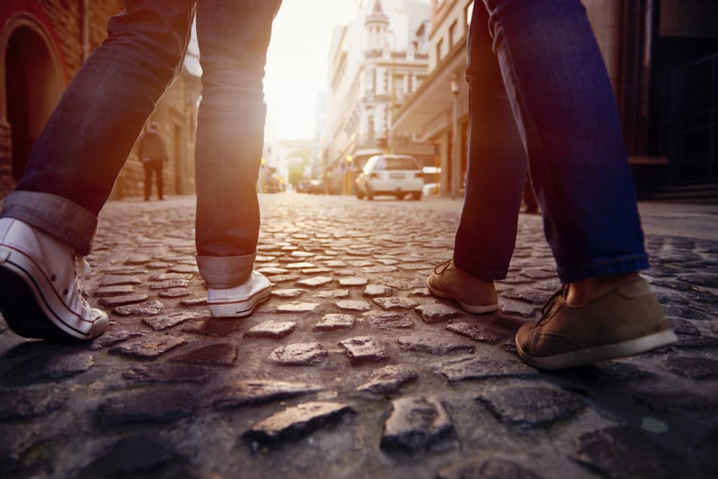 two people walking on cobblestones