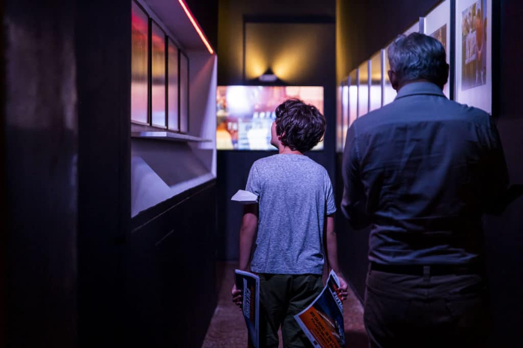 kid and older man walk along a corridor lined with Back To The Future pictures
