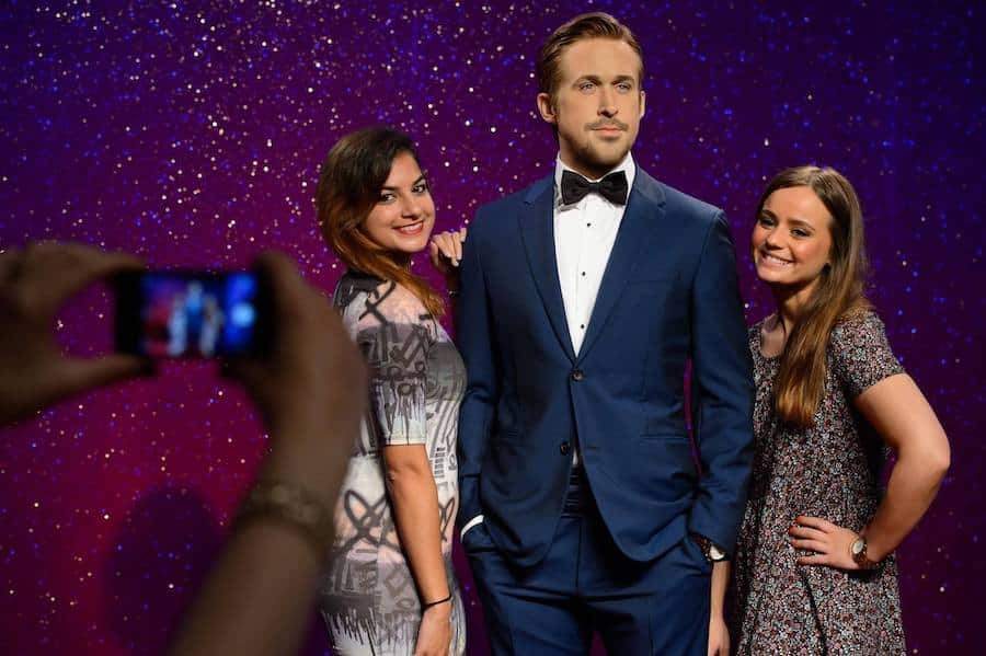 Two woman pose with Ryan Gosling waxwork