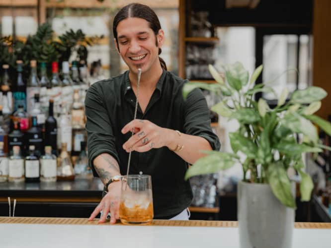 An expert mixologist mixing a cocktail at the Roof Garden at Pantechnicon