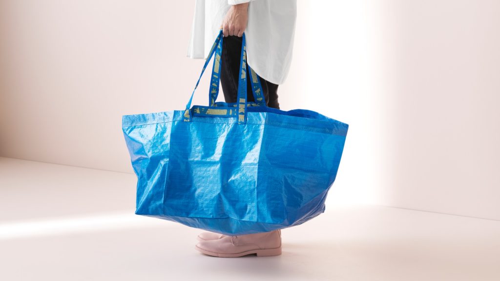 someone in a white room holding an IKEA FRAKTA bag
