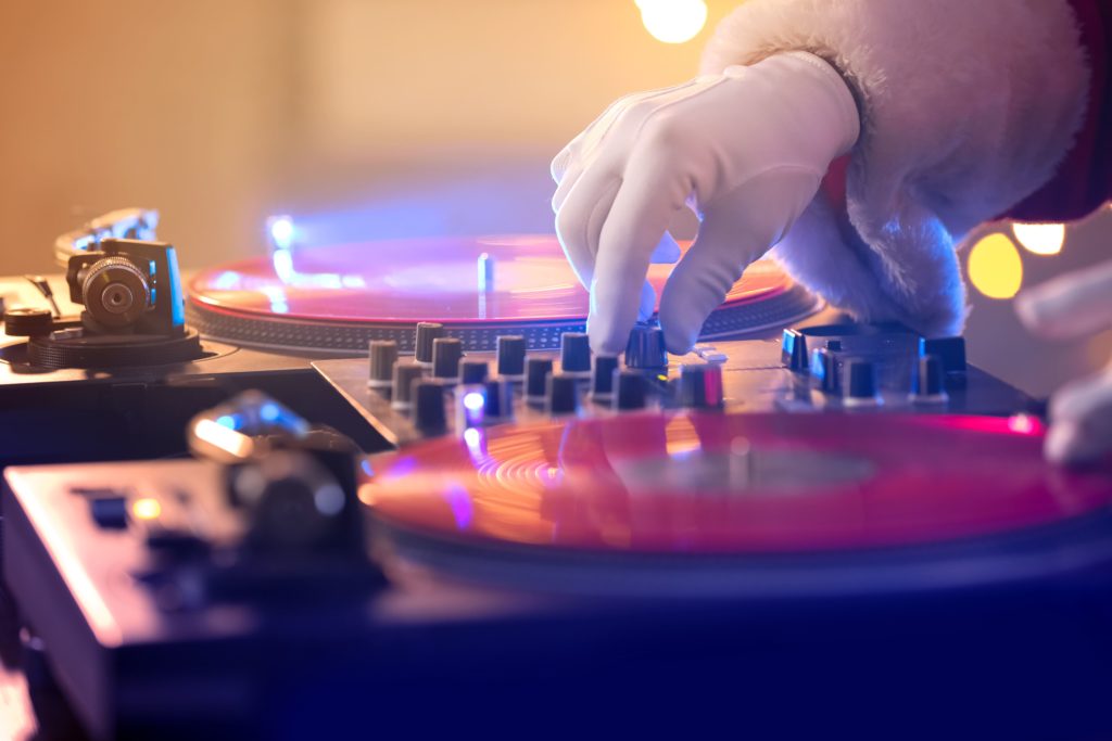 santa toggling some switches on a dj deck
