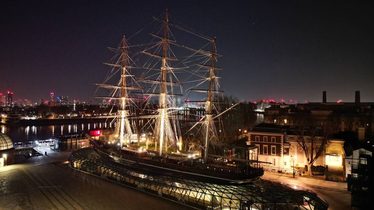the cutty sark - a large ship/museum moored on land - as seen from above at night in greenwich
