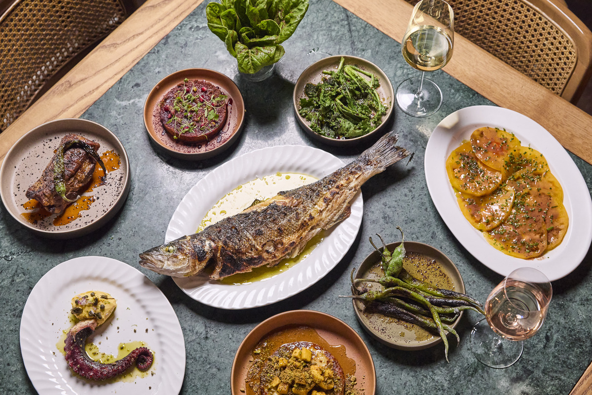 a spread of food from new opening The Counter Soho, with a whole roasted fish at the centre of it all