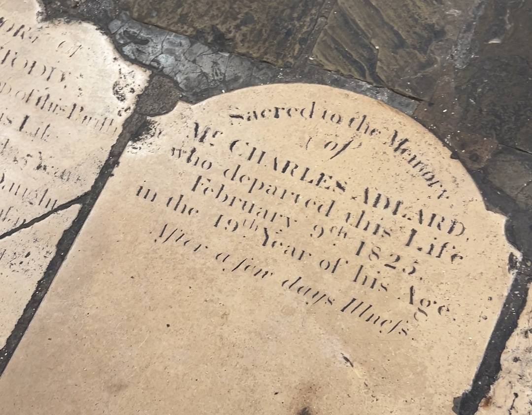 A memorial stone on the floor of the cafe in the crypt