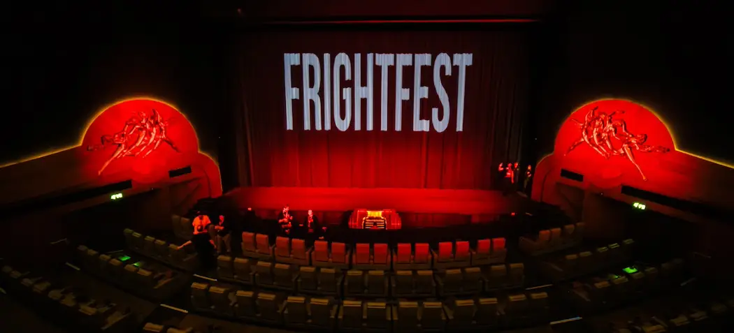 logo of fright fest projected on red curtains in a cinema with red coloured seating surrounded a stage platform