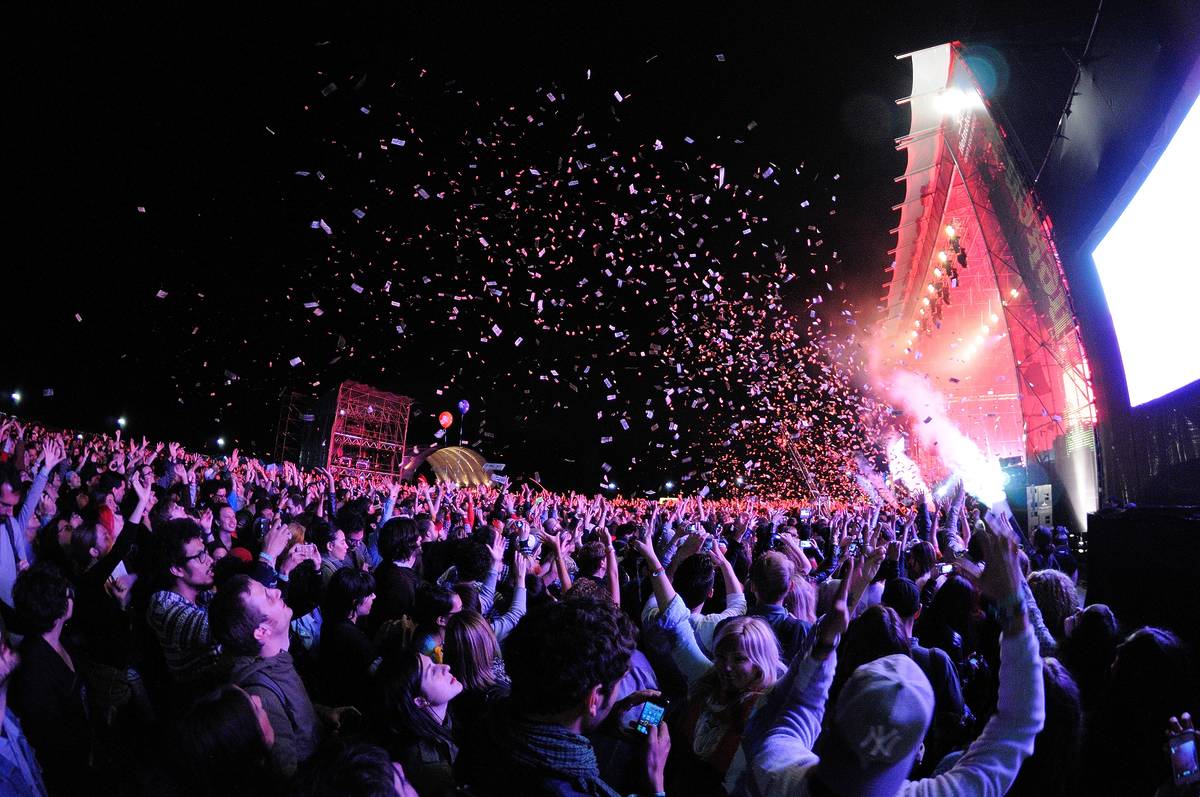 People watching a concert, while throwing confetti from the stage at Heineken Primavera Sound