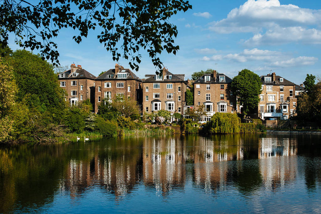Row of houses infront of body of water in Hampstead Heath, London.