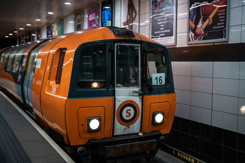 a white and orange train in the glasgow public transport system