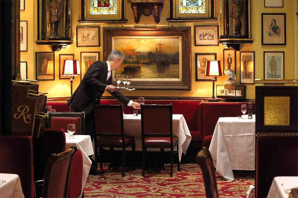 Mann deckt einen Tisch in einem Restaurant