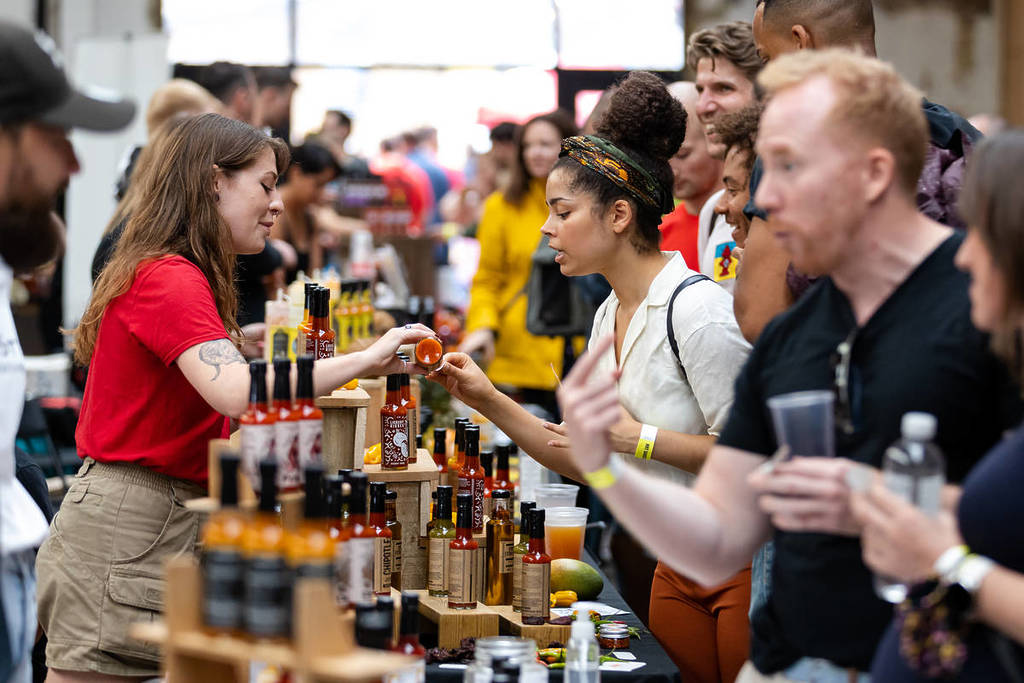 attendees at a hot sauce festival milling about and trying hot sauces
