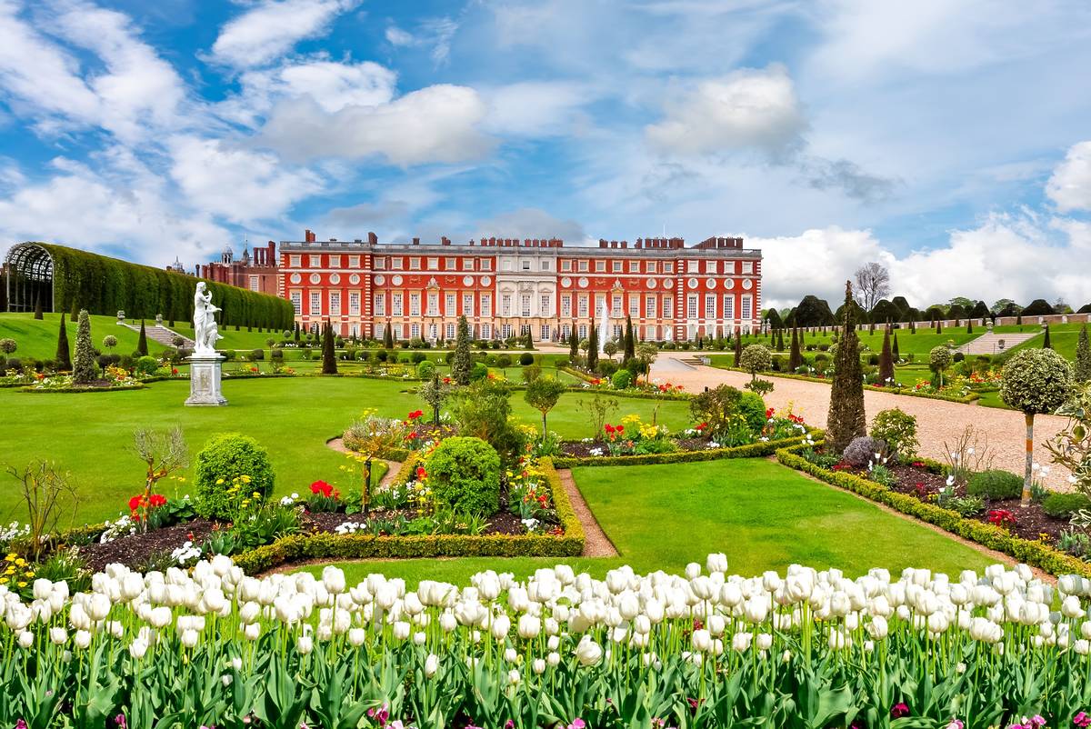 Hampton Court Palace and its surrounding gardens on a sunny day