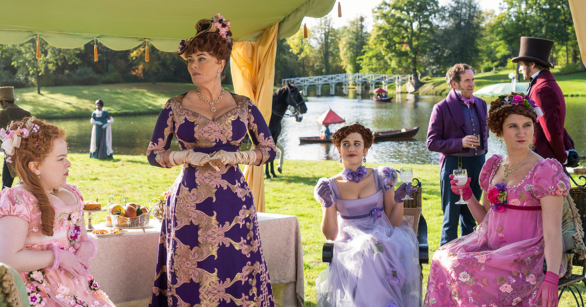 A scene in Bridgerton with cast members sat undr a gazebo in Painshill Park