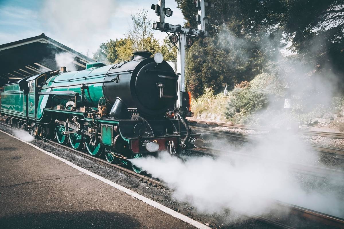 a green steam train on the romney, hythe and dymchurch railway
