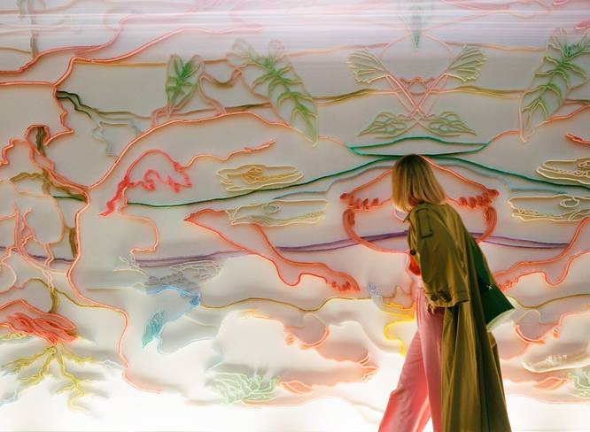 A visitor at Art Basel Paris observing a colourful artwork