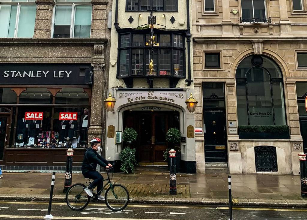 Façade du pub Ye Olde Cock Tavern avec une personne passant à vélo