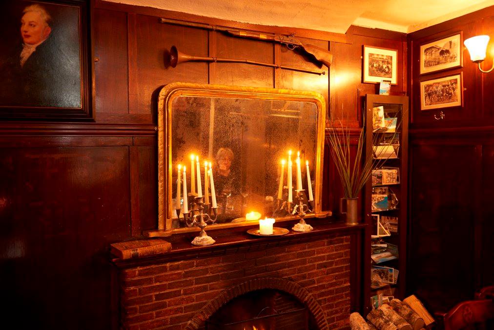 Mirror with candles and reflection of pub guest.