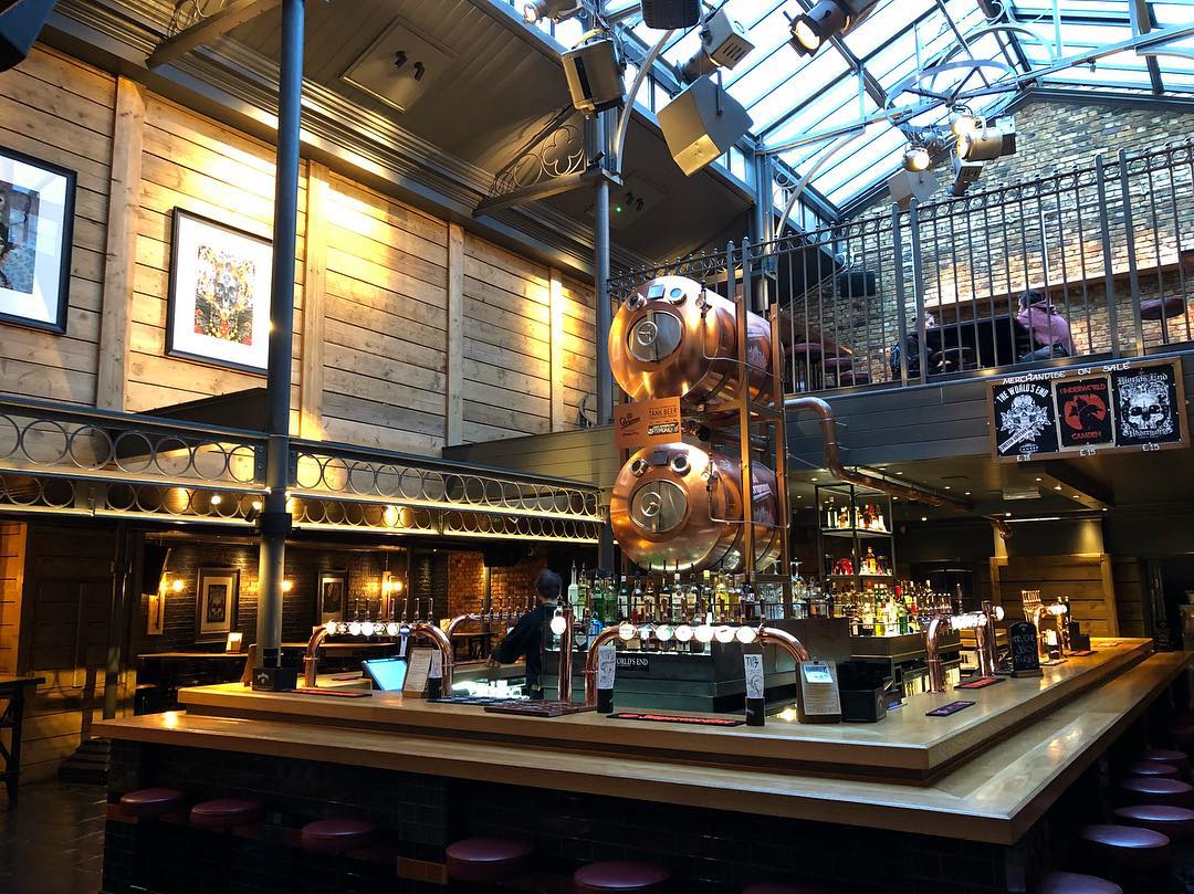 Main bar area at The World's End Pub, with metalic beer tanks and additional seating upstairs