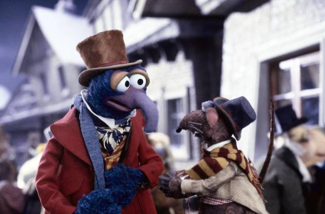 a still from The Muppet Christmas Carol movie showing the muppets Gonzo and Rizzo in Edwardian clothing walking along a street