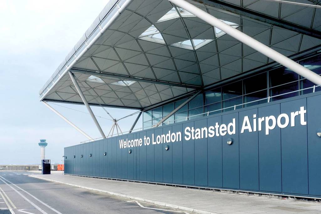 Cartel de «Bienvenidos al aeropuerto de Londres Stansted» en la pared exterior de la entrada del aeropuerto.