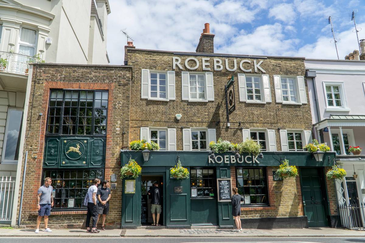 The Roebuck pub with people stood outside on a sunny day